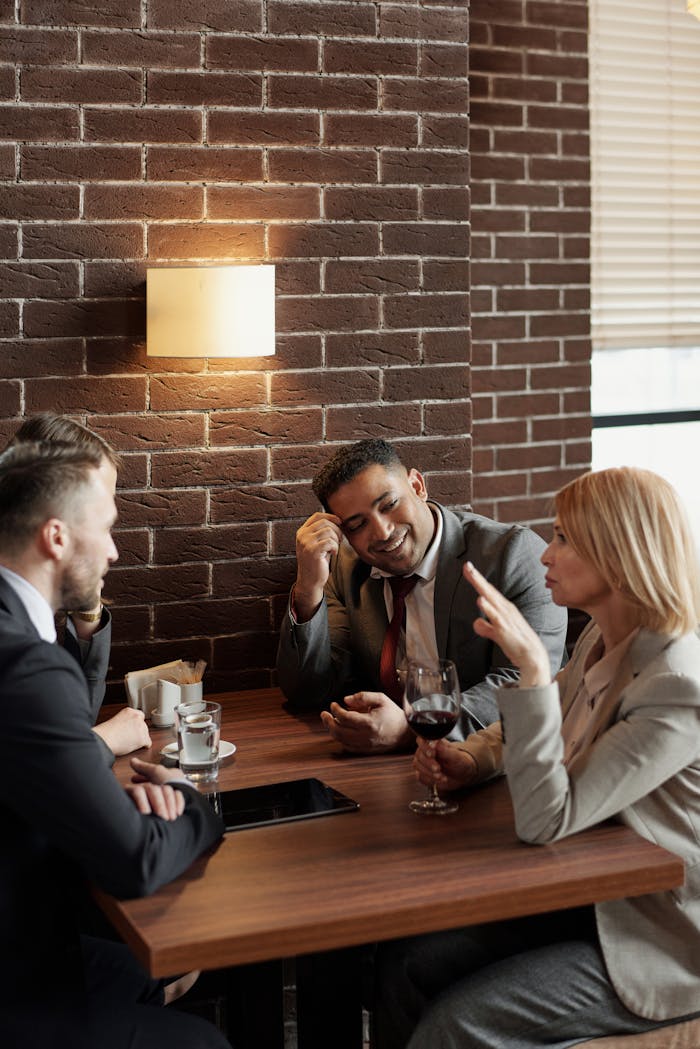 Business professionals enjoying a meeting in a cozy café setting, discussing over drinks.